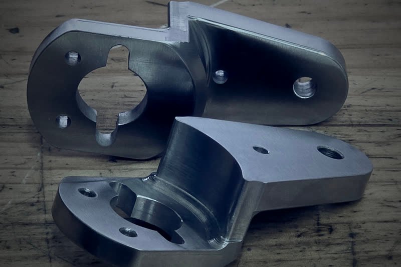 Dwa aluminiowe wsporniki techniczne po frezowaniu CNC
