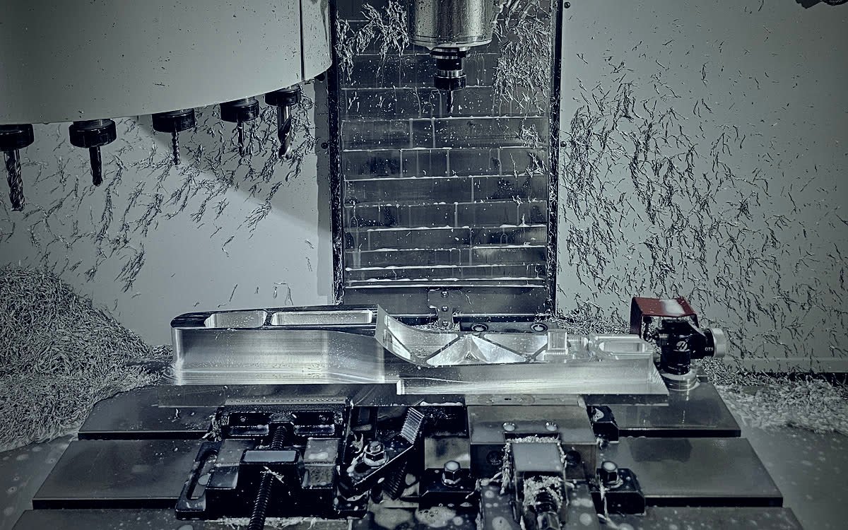Wnętrze centrum obróbczego CNC Haas z detalem aluminiowym zamocowanym na stole